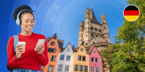 A smiling young woman looks down at her phone while holding a white to-go coffee mug. She is framed by a photographic background with colourful multistorey houses, a warm-hued stone castle, and a German flag logo.