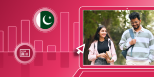 Two international students walk together on a campus pathway. Their image is framed by a red illustrated background and a Pakistani flag (a white crescent moon and a white star on a dark green field).