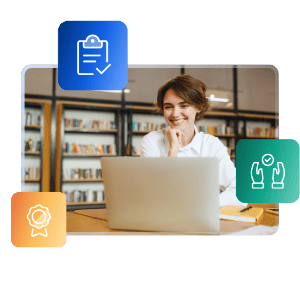A smiling female student sits in a library, looking at an open laptop