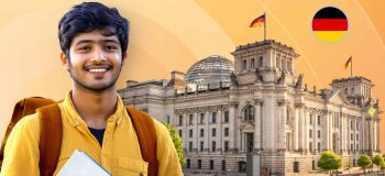 A smiling student wearing a backpack stands in front of a multistorey building with a German flag on top.