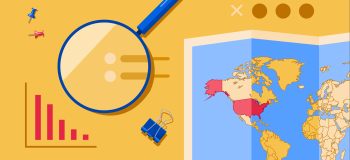 A magnifying glass and a map of the world with the United States highlighted